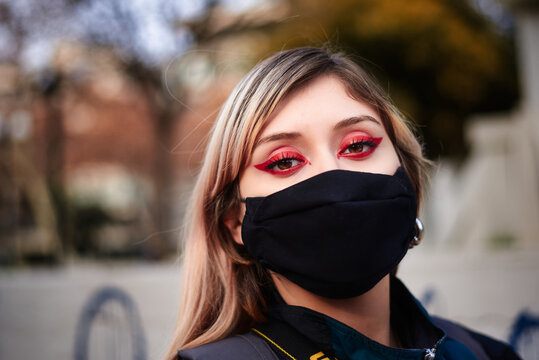 Woman In Town Wearing Protective Face Mask. Woman wearing face mask because of pollution. Girl walking wearing a mask in the city street. Air pollution or virus epidemic in the city