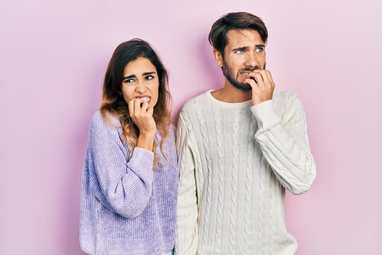 Young hispanic couple wearing casual clothes looking stressed and nervous with hands on mouth biting nails. anxiety problem.