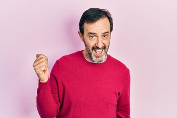 Fototapeta premium Middle age hispanic man wearing casual clothes smiling with happy face looking and pointing to the side with thumb up.