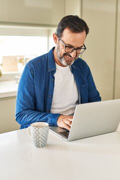 Middle age man smiling confident using laptop at home