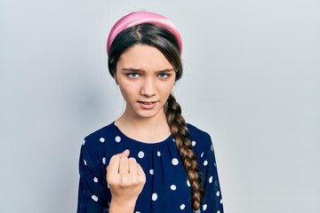 Young brunette girl wearing elegant look angry and mad raising fist frustrated and furious while shouting with anger. rage and aggressive concept.