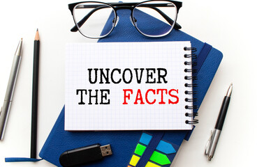 Notebook with Tools and Notes with text UNCOVER THE FACTS business