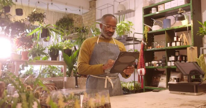 Portrait of Mature Male Florist Working on Digital Tablet in Plant Store