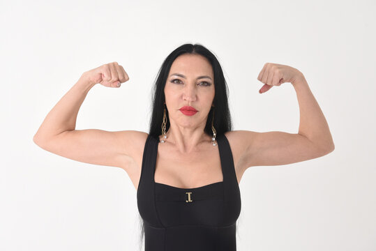 Portrait of a beautiful brunette woman in a bodybuilding pose showing muscles on a white background