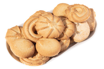 Assorted various forms of danish crumbly cookies on a white plate isolated. Shooting angle 45 degrees, harsh light from the left. 