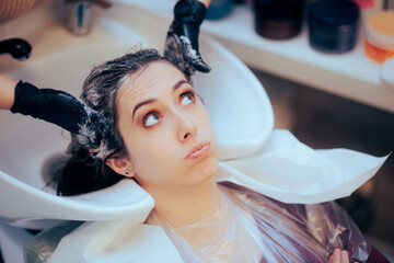 Worried Woman Having her Hair Washed by the Hairdresser 
