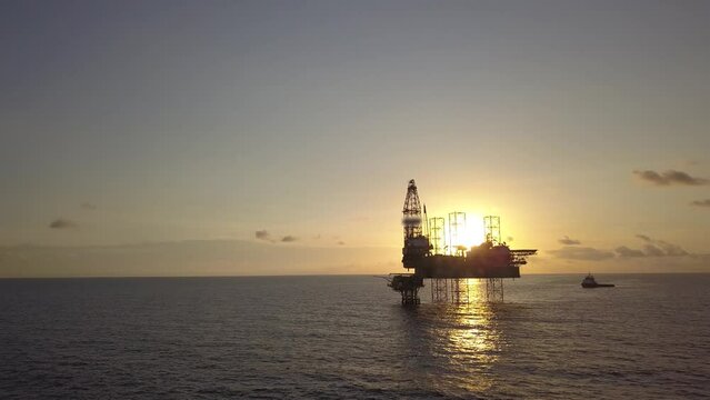 Aerial view from a drone of an offshore jack up rig at the offshore location during sunrise time