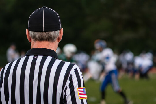 A referee observes a high school football game.