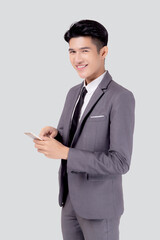 Portrait young asian business man in suit standing using smartphone to internet isolated on white background, businessman confident touch screen mobile phone with success, communication concept.