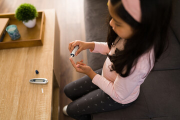 Little girl testing her glucose levels