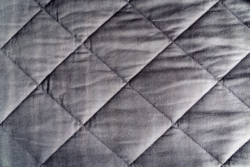 Grey weighted blanket texture detail, heavy padded relaxing bed sheet cover filled with glass beads