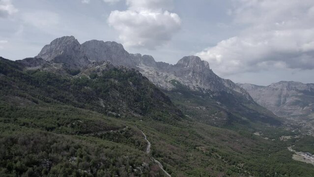Drone video of frontal plane on the Sh21 road in albania, on the way to the Theth valley, towards Mount Korab, road without traffic can be seen.