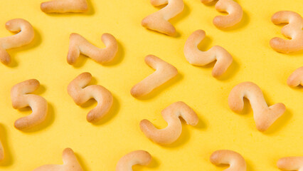 Appetizing cracker in shape numerals on yellow background