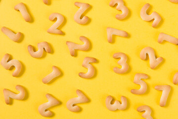 Appetizing cracker in shape numerals on yellow background