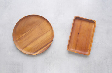 Empty wooden plate on gray cement table background, banner with copy space, Blank wood tray for food display montage, template, mock up, top view, flat lay