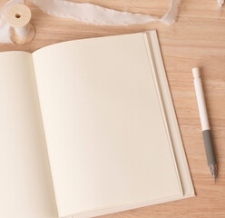 Naklejka na ściany i meble Blank notebook mockup and pen on a wood table background, Flat lay, top view, copy space