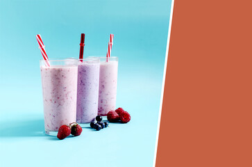 Milkshakes with natural berries in transparent dishes on a light divided background. Cocktails made of ice cream, milk and berries on a colored background.