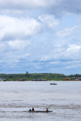 Balsas barcos navegando en el rio Ucayali en un día soleado con nubes en Pucallpa, Ucayali, Perú...