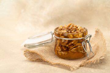 Walnuts in honey close-up. Jar of honey and nuts on a wooden background. Sweet and healthy eating dessert rich in nutrient