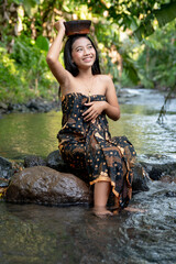 Beautiful young Asian girl rests and bathes in the river