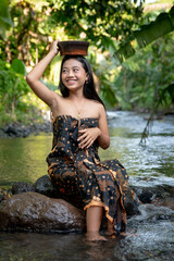 Beautiful young Asian girl rests and bathes in the river