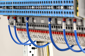 Colored electrical wires with markings connected to electrical terminals in close-up.