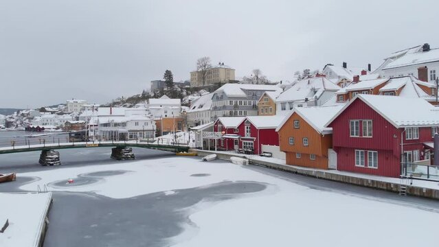Bridge Over Frozen Water With Norwegian Houses And Buildings In Kragerø, Norway. - aerial