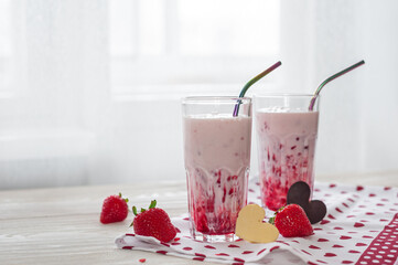 Sweet milk dessert on Valentine's Day. Delicious strawberry yogurt decorated with heart-shaped chocolate on a wooden table. Side view. Selective focus. Healthy breakfast.