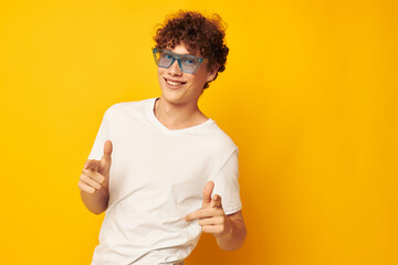 portrait of a young curly man in a white t-shirt blue fashion glasses isolated background unaltered