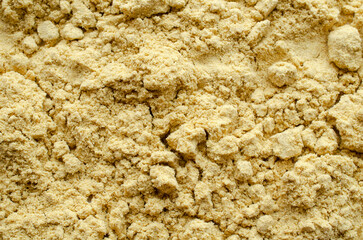 Yellow mustard powder background, top view. Texture of yellow mustard powder, top view. Heap of mustard powder, spice, background, texture.