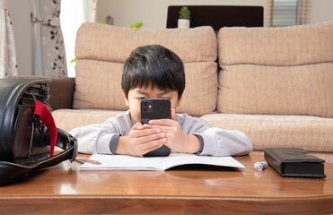 勉強中にスマホを見る小学生の男の子