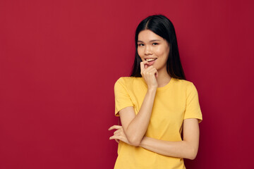 Obraz premium Portrait Asian beautiful young woman in a yellow t-shirt gesturing with his hands fun isolated background unaltered