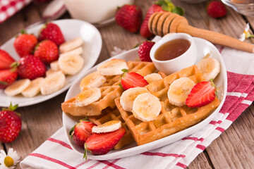 Waffles with strawberries, bananas and honey.