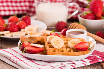 Waffles with strawberries, bananas and honey.