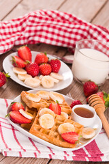 Waffles with strawberries, bananas and honey.