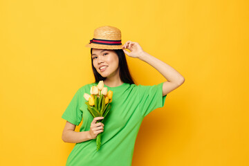 pretty brunette green t-shirt a bouquet of yellow flowers in a hat isolated background unaltered