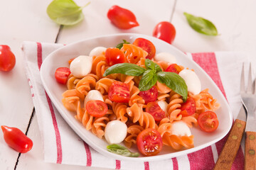 Fusilli pasta with cherry tomatoes and mozzarella cheese.