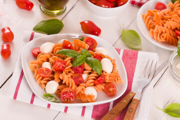 Fusilli pasta with cherry tomatoes and mozzarella cheese.
