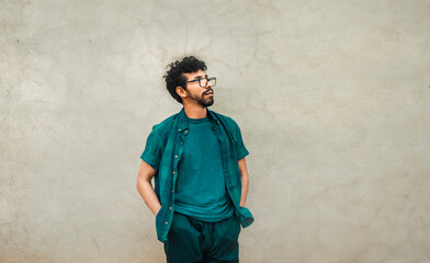 Pensive young latin man with hands in his pocket, pensive young man looking up