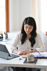 Portrait with Attractive businesswoman working at office desk, mortgage property insurance dream moving home and real estate concept.