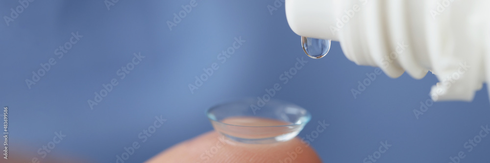 Sticker solution is dripped onto soft contact lens closeup