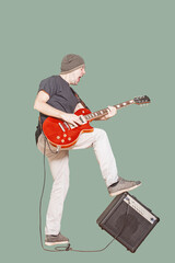Rockstar with guitar leans foot on amp while playing. Full length vertical shot of vocalist playing...
