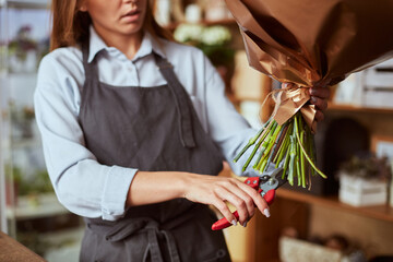 Florist cutting stems with garden pruner for freshly made bouquet