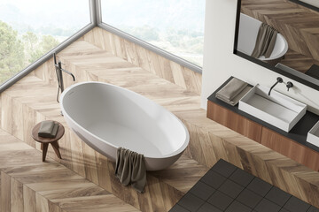 Top view of light bathroom interior with bathtub and window with countryside