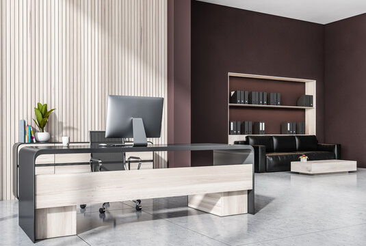 Stylish office interior with wooden panels and red brown wall, CEO workplace, Lounge area on background with couch and bookshelves with folders. Tiled concrete floor. 3d rendering
