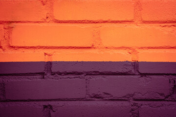 Purple or fuchsia and orange brick wall texture background. Street art detail. Colour block. Geometric pattern, lines on house wall. Creative, stylish backdrop. Painted stone structure. Copy space