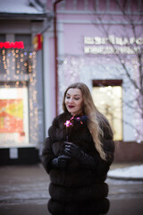 portrait of a girl in winter in a fur coat with sparkler