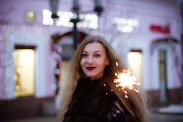 portrait of a girl in winter in a fur coat with sparkler