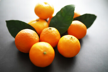 Citrus fruits on a gray background. Tangerines with leaves. Christmas fruit.
