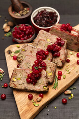 Sliced Traditional French terrine covered with bacon on dark wooden background